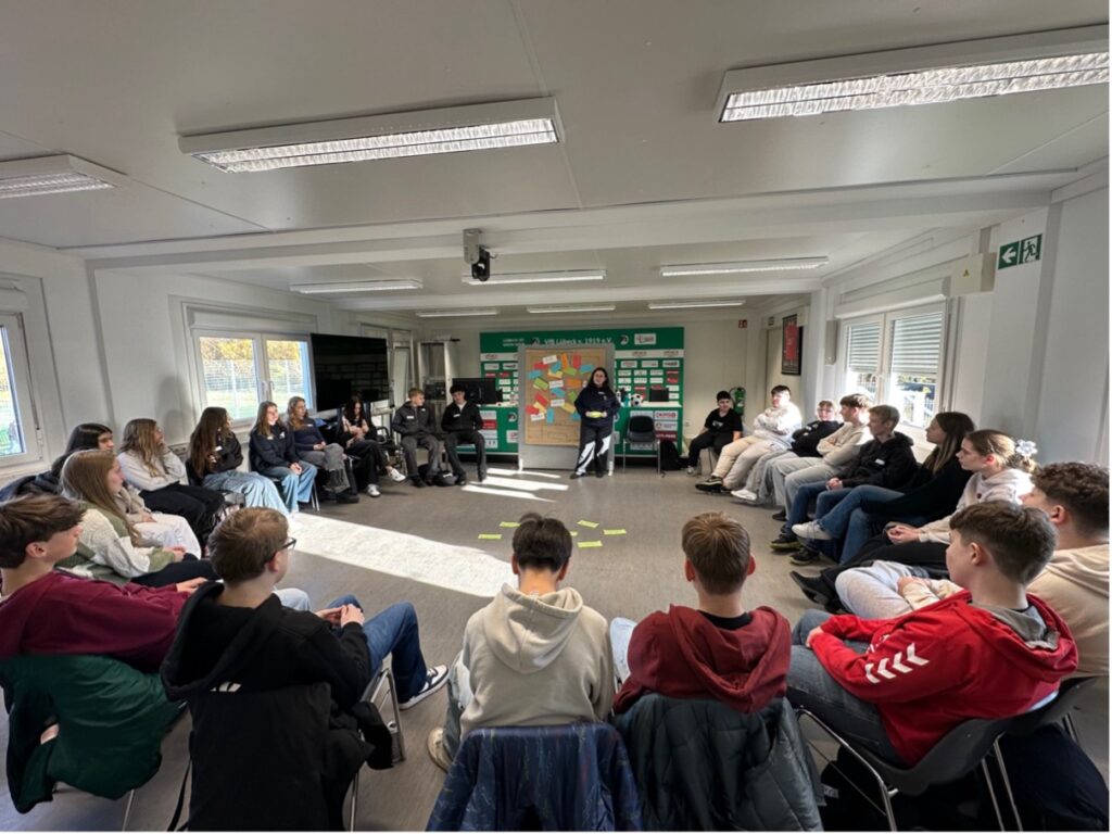 Rebecca Belfor vom Fanprojekt Lübeck und Klasse 8c der Schule Tremser Teich im Workshop zum Thema Teamfähigkeiten.